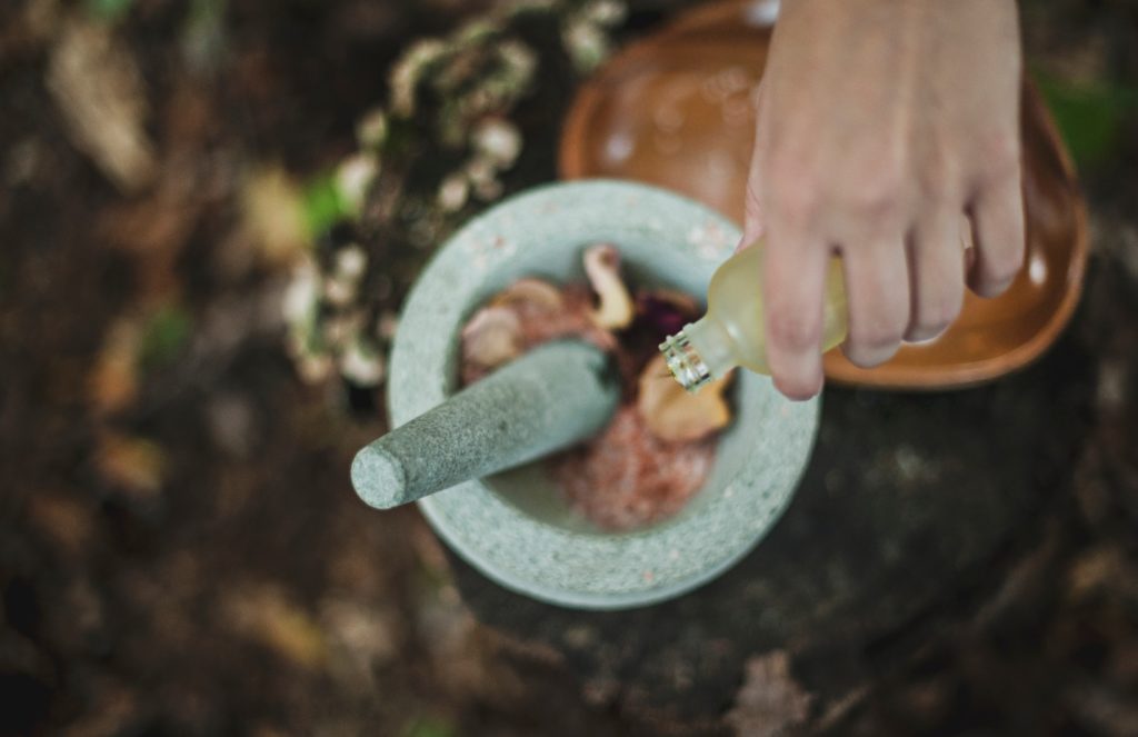 mixing herbs and oils with mortar and pestle