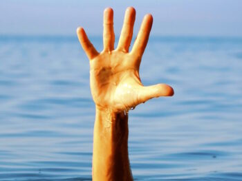 single hand reaching out of water