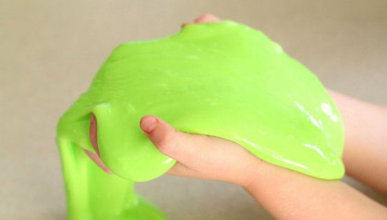 pair of hands holding green slime