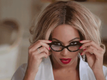 woman looking over edge of glasses