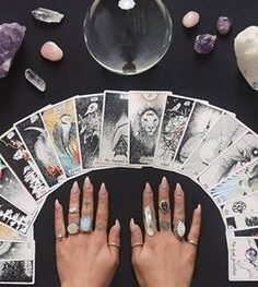 tarot cards displayed with crystal ball and woman's hands