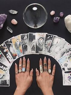 tarot cards displayed with crystal ball and woman's hands