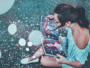 woman opening book with glitter